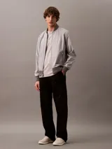 Remera gris claro de algodón con cuello redondo y manga corta. Presenta un estampado tonal con el logo de Calvin Klein Jeans en el pecho.