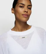 Buzo de manga larga color blanco, tejido en punto abierto (malla), con cuello redondo y corte holgado.