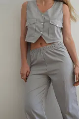 Pantalón de vestir a rayas verticales blancas y negras, con cintura elástica.