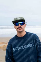 Lentes de sol deportivos con marco negro envolvente y cristales espejados en tono azul verdoso.