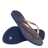 Sandalias Havaianas Slim Nautical, con base azul marino a rayas y estampado de motivos náuticos en beige. Tiras finas color bronce.