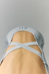 Mono corto tejido de color celeste, sin costuras y con espalda descubierta con tiras cruzadas.