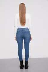 Pantalon jean de corte skinny y tiro alto, color azul clásico con costuras en tono ocre.