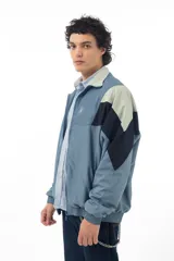 Campera deportiva azul con recortes en negro y verde agua, cierre frontal con cremallera y cuello tipo mao.