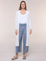 Cardigan largo de punto liviano y suave, de color blanco, con diseño abierto al frente, mangas largas con puños acanalados y bolsillos frontales aplicados.