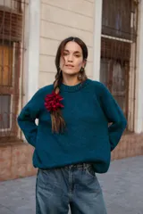 Buzo de lana color rosado, con cuello redondo, mangas largas y diseño holgado.