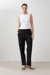 Pantalón de corte recto en color beige, con cintura media y cierre frontal oculto. Presenta un diseño limpio y minimalista con bolsillos laterales.