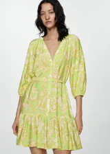 Vestido corto de tejido fluido con estampado paisley en tonos verde lima y crema. Presenta escote en pico, cierre frontal con botones, mangas tres cuartos con puños elásticos y falda con detalle de volante en el bajo. Incluye un cinturón fino del mismo tejido para ajustar a la cintura.