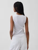 Musculosa marrón oscura de tejido pointelle, con cuello redondo y ribetes con terminación en ondas.