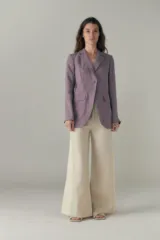 Blazer lila de lino con ruedo curvo, solapas con muesca, cierre frontal con un botón, bolsillos ojal con solapa y tajo en la espalda.