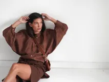 Camisa de lino blanca, de corte oversize, con mangas largas abullonadas, cuello mao y botones. Es más larga en la parte trasera e incluye un tajo en la espalda.