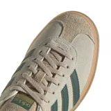 Championes adidas Gazelle Bold de diseño urbano con plataforma, confeccionados en gamuza color beige con las icónicas tres tiras laterales en verde oscuro. Presentan detalles en cuero en el talón y suela de goma con relieve.
