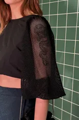 Minifalda azul con brillos, corte pareo y flecos negros en el ruedo.