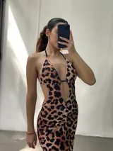 Vestido largo negro con escote halter pronunciado, espalda descubierta y abertura lateral en la falda.