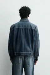Cazadora de denim de algodón con efecto lavado, cuello solapa, cierre frontal con botones y detalle de pliegues. Cuenta con bolsillos de plastrón en el pecho y mangas largas con puños abotonados.