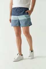 Short de baño celeste con rayas verticales blancas, cintura elástica con cordón ajustable, dos bolsillos laterales y uno trasero.