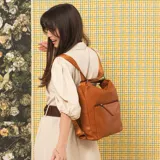 Cartera mochila negra de símil cuero con diseño convertible, bolsillo frontal con cierre y tirador, apertura superior doble y correas ajustables.