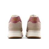 Championes urbanos New Balance modelo 574, color rosa claro con detalles en beige, blanco y burdeos, confeccionados en gamuza y malla, con logo "N" característico en los laterales y entresuela alta de plataforma.