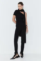 Mono largo negro de punto acanalado, con corte ceñido al cuerpo, un hombro descubierto con manga corta en el lado derecho, diseño de pantalón pitillo con abertura lateral en el bajo y detalle de banda adherida a la pieza.