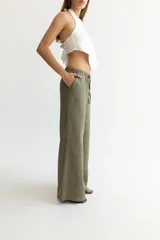 Pantalón color beige de lino, con elástico y tira ajustable en la cintura, bolsillos a ambos lados y pata de elefante estilo Oxford.