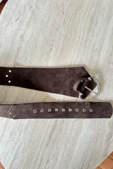 Faja ancha de gamuza vacuna color chocolate, con hebilla metálica plateada y detalles de remaches metálicos decorativos.