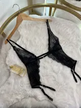 Conjunto de lencería negro de encaje, compuesto por un corpiño triangular con tirantes finos y portaligas con ligas regulables.