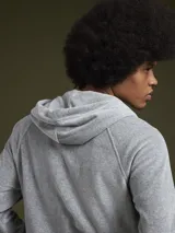 Buzo hoodie gris con capucha y cierre frontal.