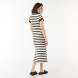 Vestido largo de punto a rayas horizontales blancas y negras, con mangas cortas, cuello tipo polo negro y escote en V.