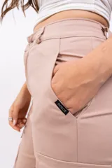 Pantalón cargo color beige con bolsillos laterales y tobillos ajustables con cordón.