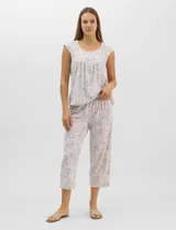 Pijama compuesto por remera sin mangas con escote redondo, botones frontales y detalle de puntilla, acompañado de un pantalón capri con cintura elástica. Presenta un estampado floral en tonos rosados sobre base gris.