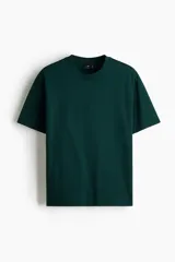 Remera en punto de algodón verde oscuro, con cuello redondo ribeteado, hombros caídos, mangas cortas y bajo recto de corte relajado.