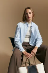 Polera de punto acanalado color gris, con cuello alto y mangas largas, de calce ajustado al cuerpo.