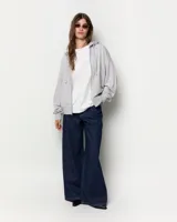 Buzo oversize negro con cierre frontal completo y capucha con cordón ajustable.