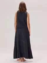 Falda larga color marrón, con diseño de corte asimétrico y tablas en el ruedo que aportan movimiento. Confeccionada en una mezcla de algodón y tencel.
