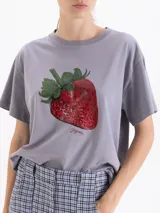 Remera de algodón color gris con estampa frontal de una frutilla realista.