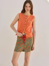 Short holgado de cintura alta con pretina integrada, cordón ajustable delantero y estampado geométrico en tonos rojos y beige.