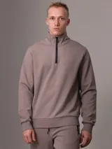 Buzo color topo de Calvin Klein, con cuello alto y media cremallera negra.