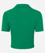 Blusa de cuello polo y manga corta, confeccionada en tejido rib de algodón con elastano. Presenta un diseño ajustado al cuerpo con escote en V y textura acanalada.