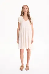 Vestido corto de viscosa color beige, sin mangas con volados en las sisas, escote en V y diseño escalonado.