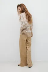 Pantalon de corte recto y tiro alto, confeccionado en un tejido de acabado suave y textura aterciopelada, con costuras verticales decorativas en el frente.