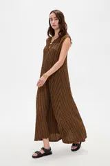 Vestido midi sin mangas de poliéster, color beige con rayas verticales negras, cuello en V y detalle de argolla metálica en el escote.