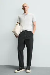Pantalón de corte carrot fit confeccionado en tejido de algodón con estructura diagonal y efecto lavado. Presenta bolsillos frontales con bolsillo cerillero, bolsillos traseros de plastrón y cierre frontal con cremallera y botón.