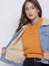 Campera de jean blanca con interior de corderito color beige, dos bolsillos grandes en la parte frontal y siete botones metálicos.