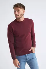 Sweater de algodón en butoné color verde, con cuello redondo, puños y dobladillo acanalados, y logo bordado en el pecho.