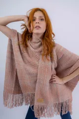 Ruana artesanal color salmón con textura rústica y flecos.