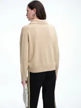 Sweater de punto color verde oliva, con cuello polo abierto en V, manga larga con hombros caídos y terminaciones acanaladas en puños y ruedo.