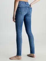 Jeans ajustados de tiro alto para mujer, en denim de algodón elástico con lavado azul medio vintage. Presentan diseño de cinco bolsillos y bragueta con cremallera.