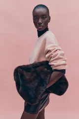 Buzo oversized rosado de punto suave, con cuello redondo y ribetes acanalados en cuello, puños y bajo. Hombros marcadamente caídos.