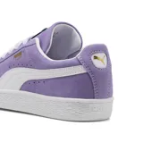 Championes Puma Suede Classic de color lila con detalles en blanco. Presentan una capellada de gamuza, la icónica franja lateral de la marca en contraste y suela de goma texturizada.