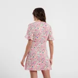 Vestido corto con estampado floral en tonos rojos y celestes, con escote en V y mangas cortas acampanadas.